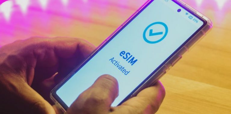 A hand holding a cell phone. The screen displays a message that says "eSIM activated."