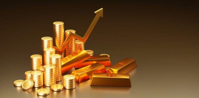 Gold bars and coins on a brown background.
