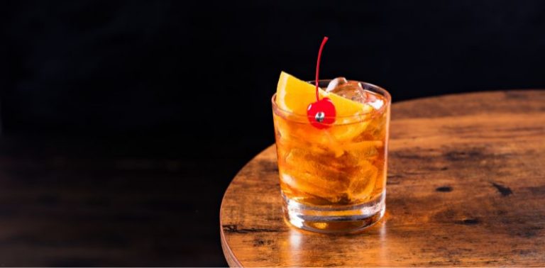 A whisky sour sitting on a table.