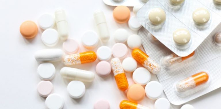 White and orange pills on a light background.