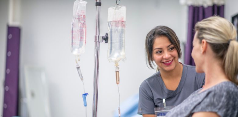 A doctor talking to a patient receiving IV treatment.